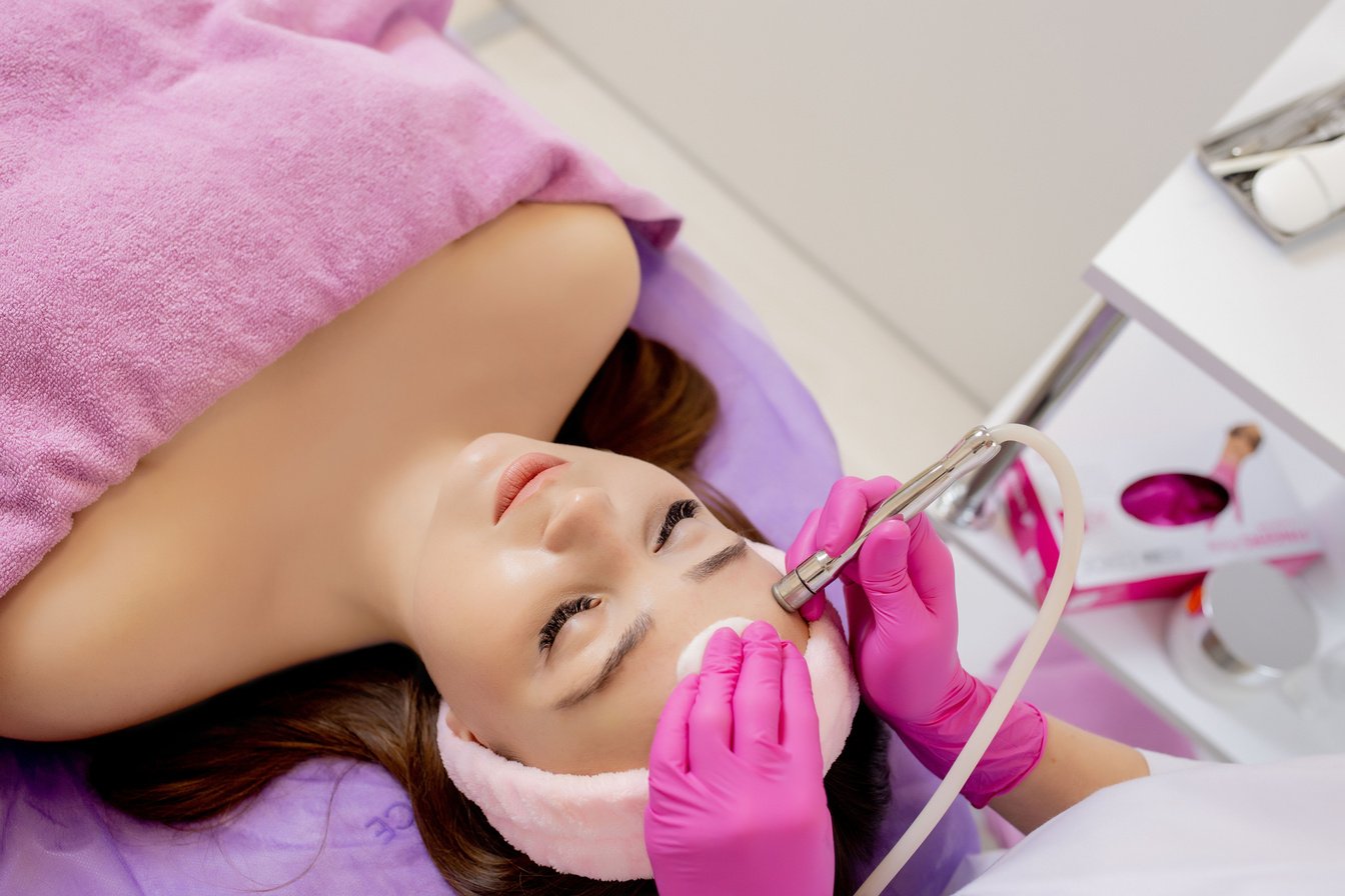 The cosmetologist makes the procedure Microdermabrasion of t