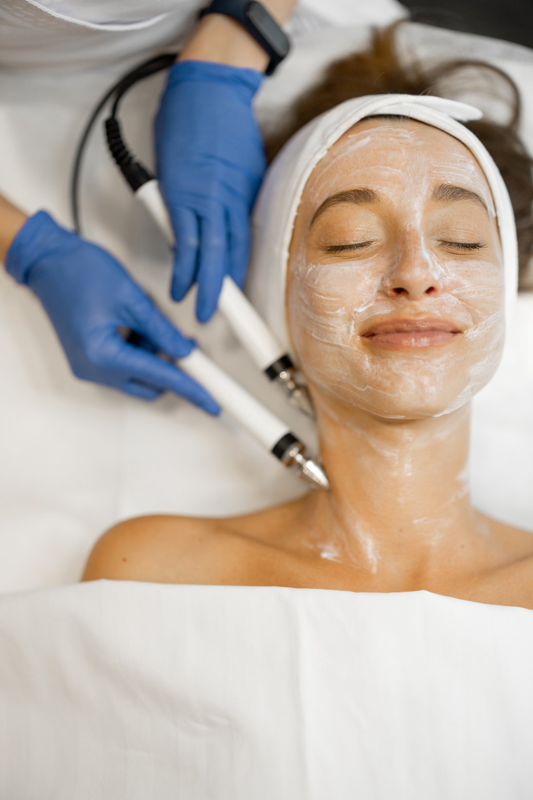 Woman Undergoing Facial Microcurrent Procedure in a Salon